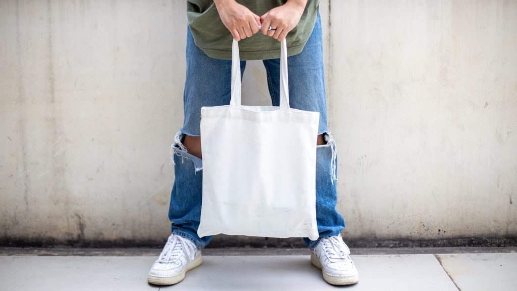 A person holding a reusable cloth bag
